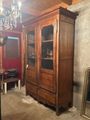 a large wooden cabinet with a glass door in a room
