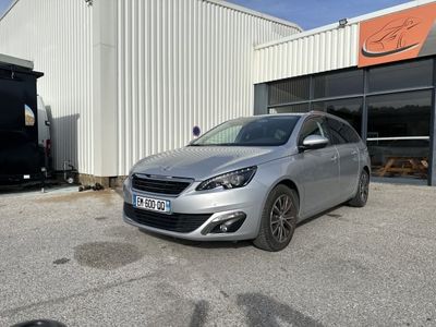 La voiture argentée est garée devant l'immeuble.