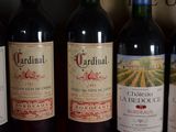 several bottles of red wine are lined up on a shelf
