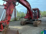 une pelleteuse rouge qui est à l'arrêt dans la terre