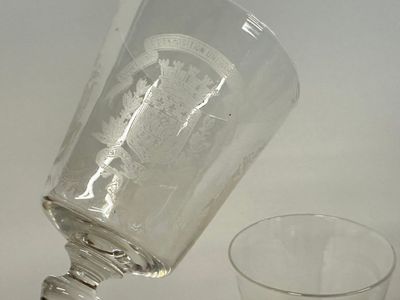 a glass with a bottle on it next to a glass with a bottle on it