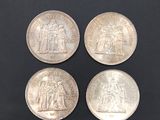three silver coins with a picture of a man and a woman on them