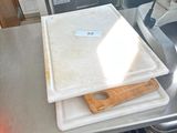 un plan de travail en acier inoxydable sur lequel est posée une planche à découper, dans une cuisine