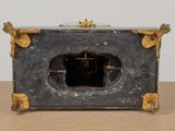 a black and gold clock sitting on top of a wooden table