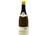 the bottle of wine is sitting on a white surface