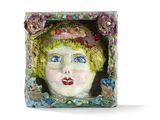 une sculpture en céramique représentant une femme coiffée d'un chapeau