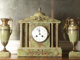 three vases and a clock sitting on a table