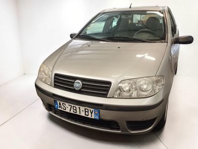 une voiture argentée garée dans une pièce blanche