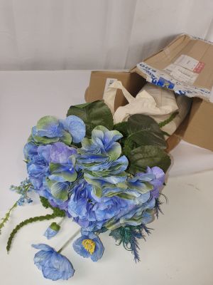 un bouquet de fleurs bleues posé sur une table blanche