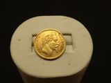 un gros plan d'une pièce d'or posée sur un objet blanc