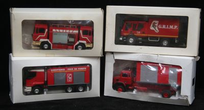 trois camions de pompiers rouges dans leurs boîtes, sur fond noir