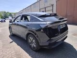 the rear end of a black car parked in a parking lot