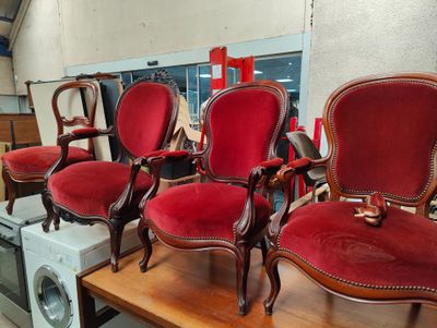 four red chairs sitting on top of a wooden table