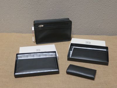 une photo montrant un portefeuille, un porte-cartes et un étui pour téléphone posé sur une table