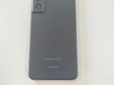 the back of a black samsung galaxy s20e phone on a white surface