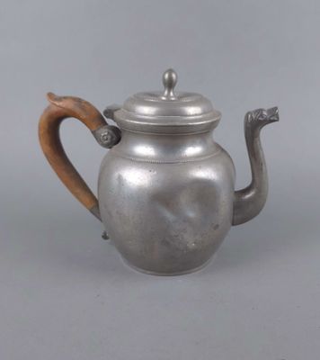 théière en argent avec une poignée en bois sur fond gris, avec un fond gris