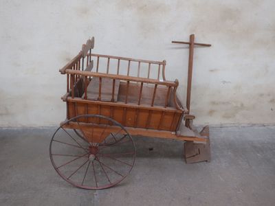 a small wooden wagon with a bed on the back of it