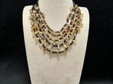 a white mannequin with a yellow and black necklace on it