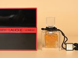 a bottle of perfume sitting on top of a table next to a box