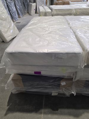 many mattresses stacked on top of each other in a warehouse