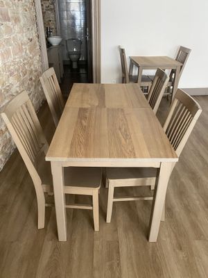 a wooden table and chairs in a room with a brick wall