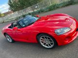 a picture of a red sports car parked in a parking lot