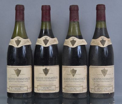 four bottles of wine are lined up on a table