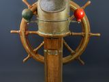 une barre de bateau en bois et en laiton surmontée d'une boule rouge
