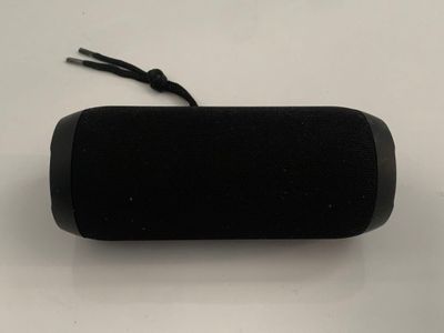 an image of a black speaker sitting on top of a white table