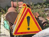 panneau d'avertissement jaune et rouge posé au sommet d'un tas de vieilleries