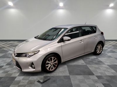 La Toyota Corolla est garée dans une pièce dont le sol est en damier.