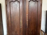 une armoire en bois dans une pièce, avec une chaise à côté