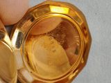 a person holding a gold pocket watch in their hand