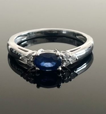 an image of a sapphire and diamond ring on a black surface