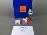 a small figurine of a man with a dog next to a blue box