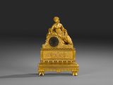 l'image d'une horloge en or sur laquelle est assise une femme