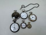 many different types of pocket watches on the table