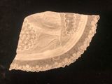 une vieille photo d'un chapeau blanc orné de dentelle