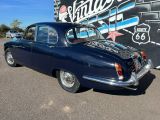 une vieille voiture bleue garée devant un panneau vintage de la Route 66