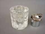 a glass of water next to a small silver container