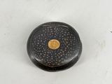 an image of a small black and gold box on a white surface