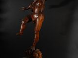 a bronze statue of a boy on a pedestal with a ball