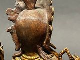 bronze statue of a woman holding a bird on her shoulder
