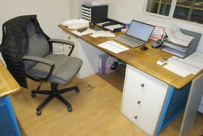 a computer desk with a chair and a laptop on it