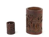 two wooden vases with carvings on them sitting next to each other
