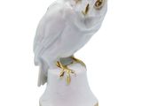 an owl figurine sitting on top of a white pedestal