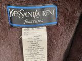the label on the back of a brown teddy bear that is on a person ' s arm