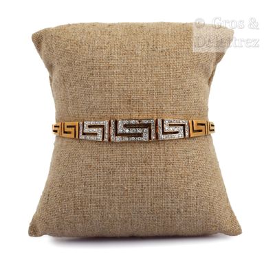 a close up of a pillow with a gold and silver bracelet on it