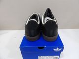 black and white adidas shoes on a blue box on a white surface