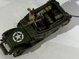 a toy army vehicle with soldiers in it on a table